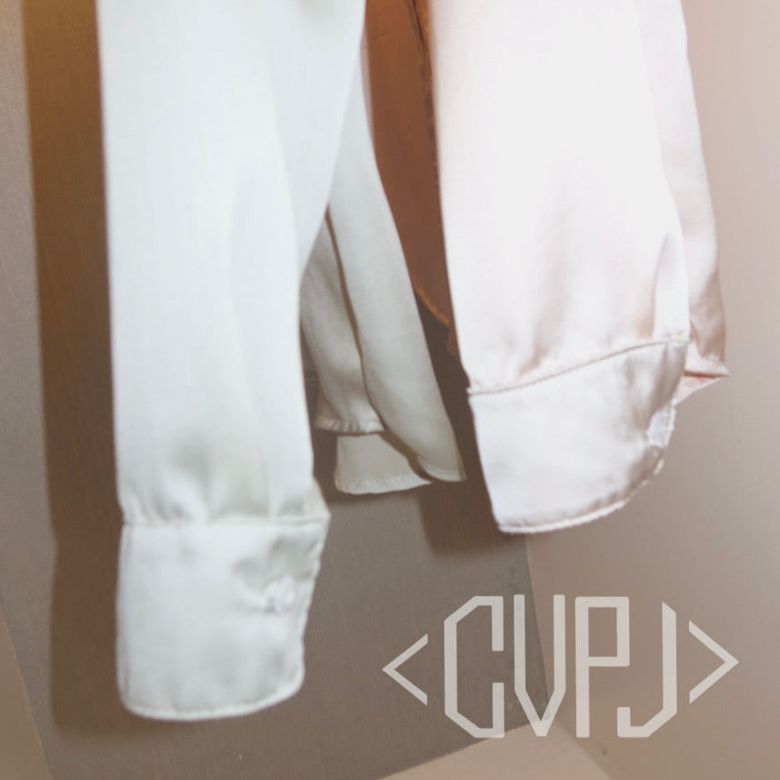 White shirt with rolled-up sleeves on a neutral background